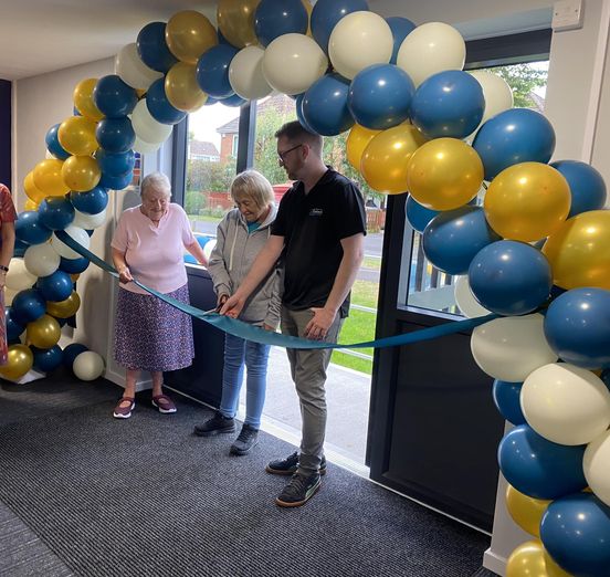 Homes in Somerset colleagues and customers cutting a ribbon at the Chichester Close Communal Hall Opening
