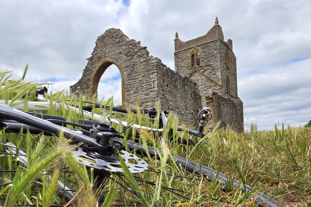 Picture of a bike on a hill with an old ruin behind it.